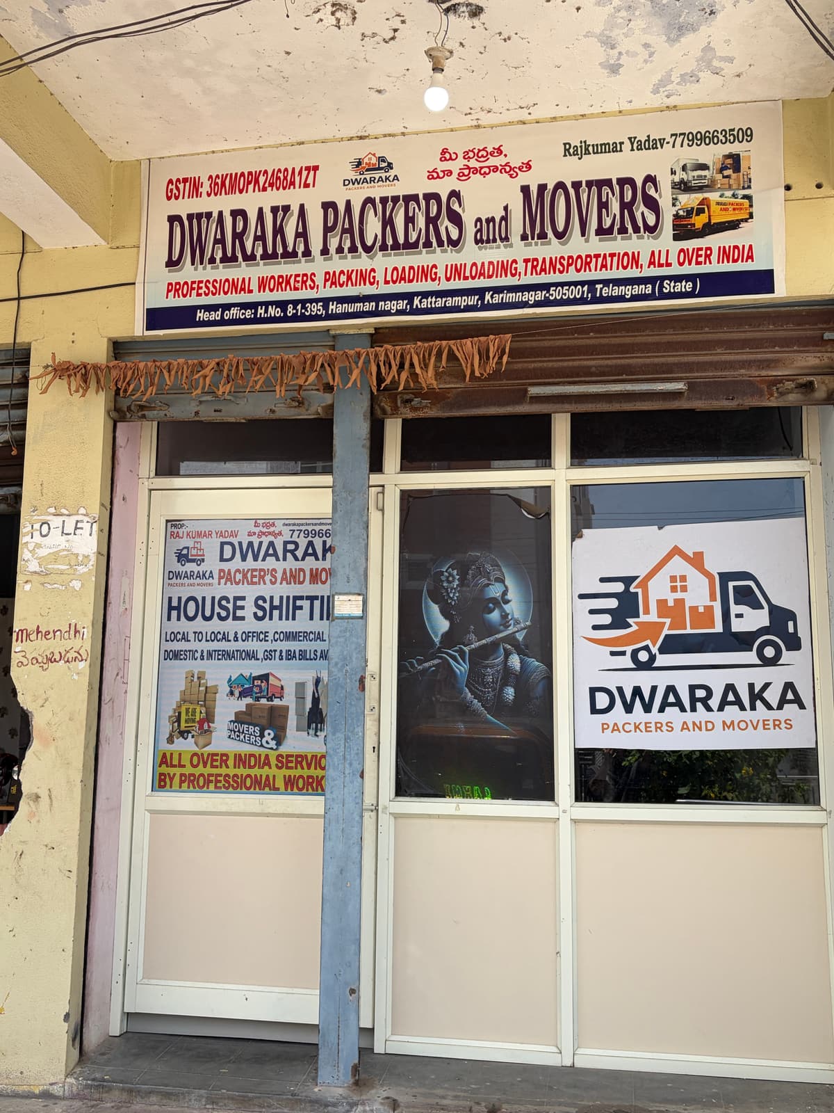 Dwaraka Packers and Movers head office signboard in Karimnagar showing the company name, GST number and contact details